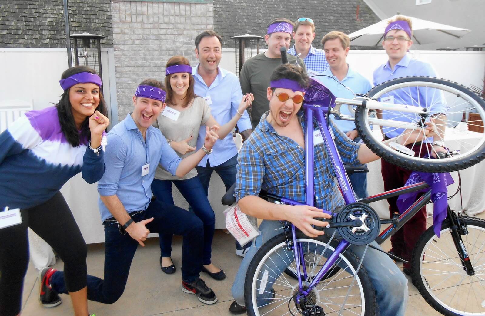 People air guitaring and holding a bike